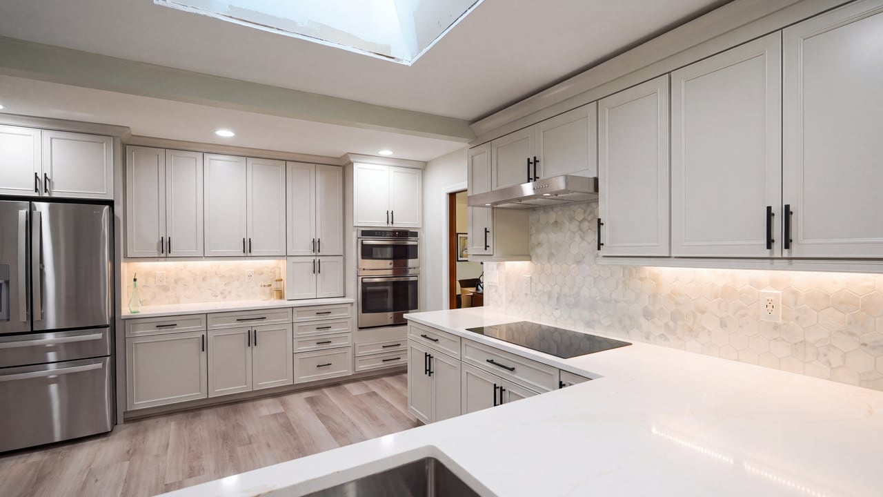 Pale stone countertops meeting white cabinetry in a renovated kitchen